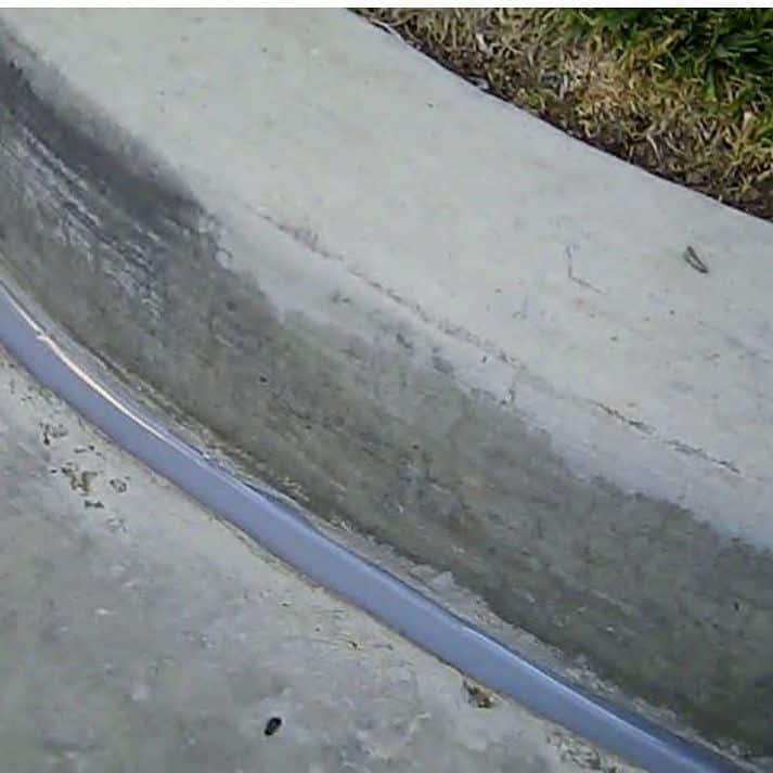 Concrete curb with gray strip along edge