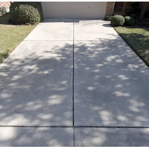 Concrete driveway leading to closed residential garage