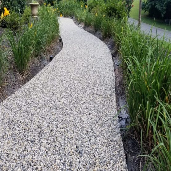 Curved pebble pathway through landscaped garden